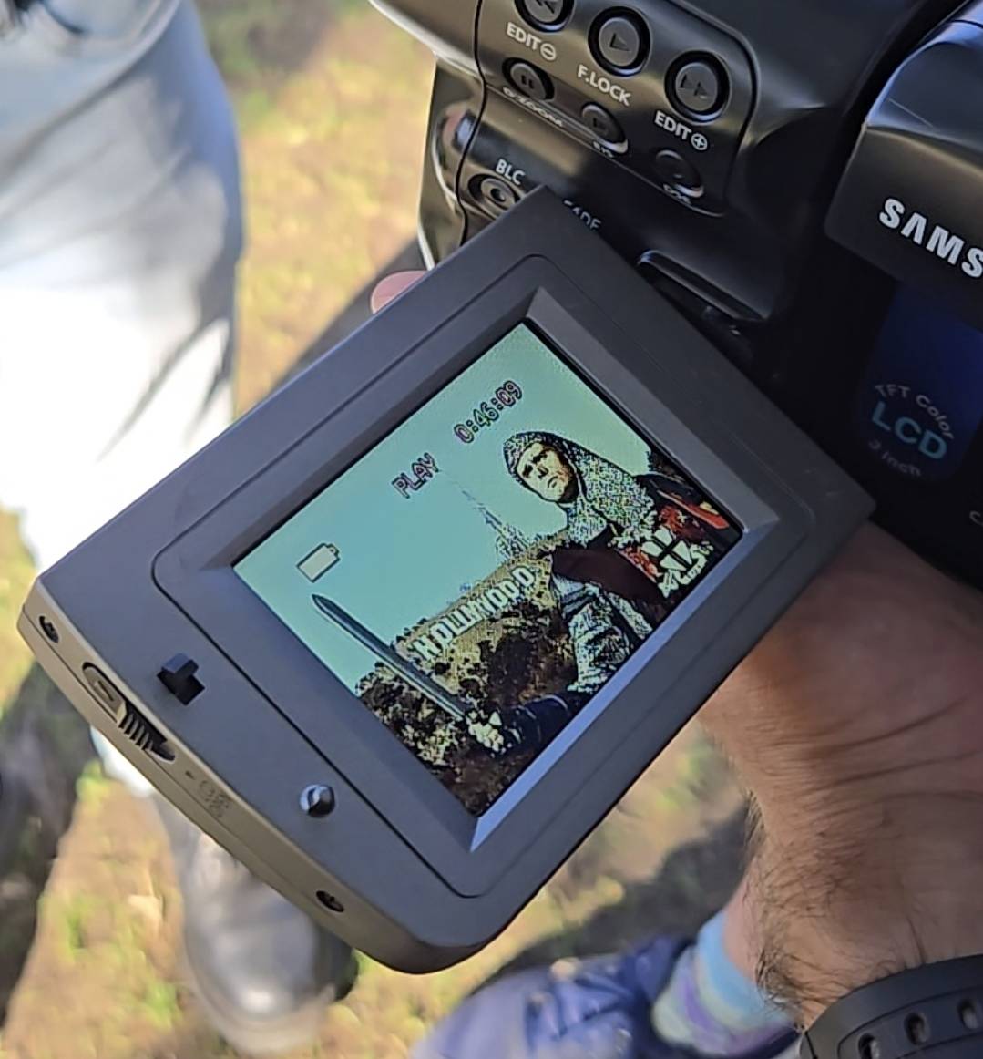 Camera screen displaying a photo of a person in front of the Hollywood sign.