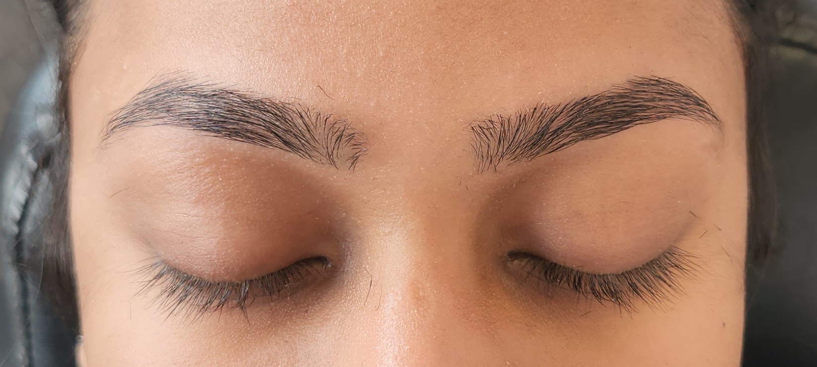 Close-up of closed eyes and eyebrows with natural skin tone.