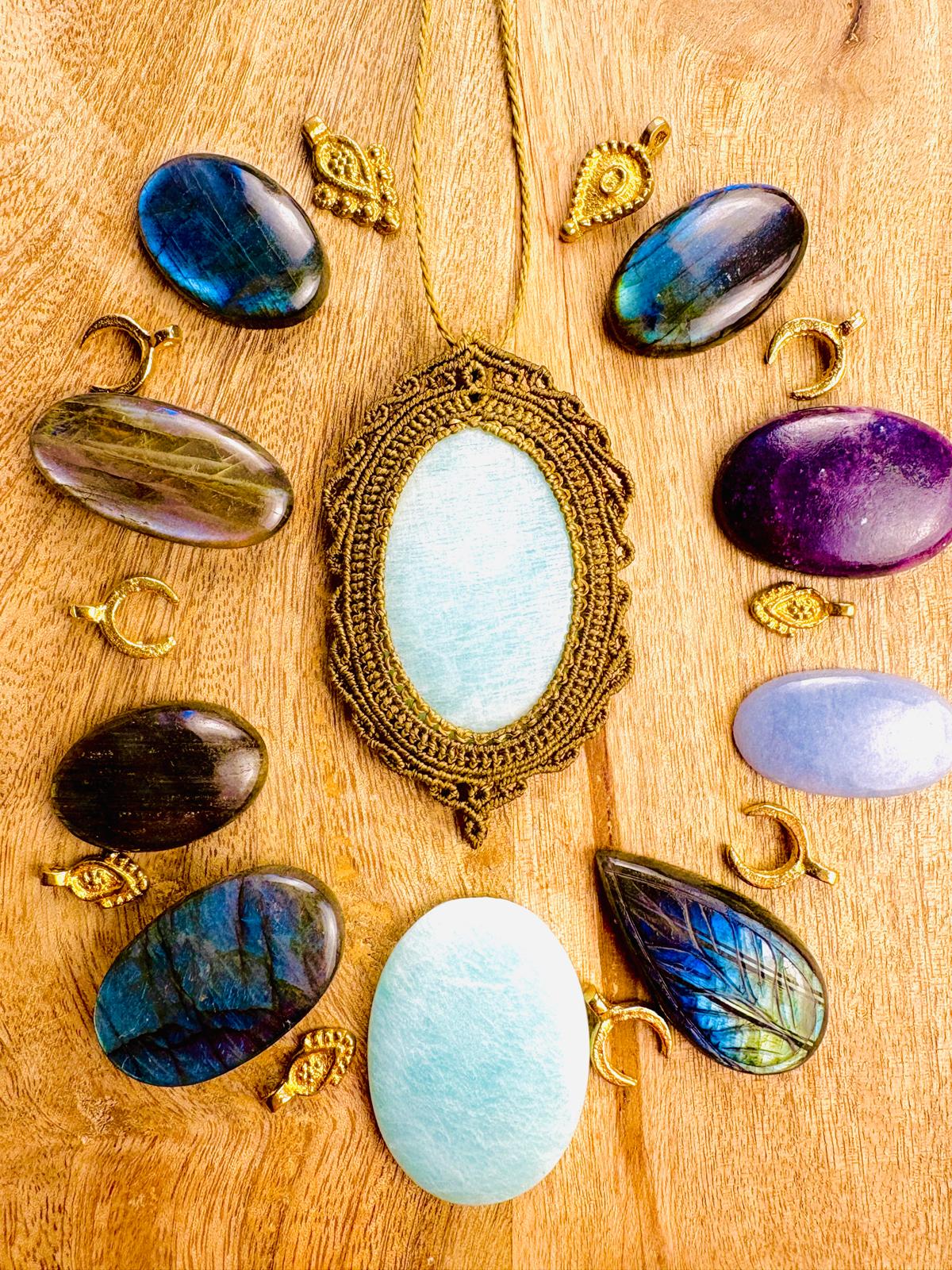 Decorative pendant surrounded by colorful oval beads on wooden surface.