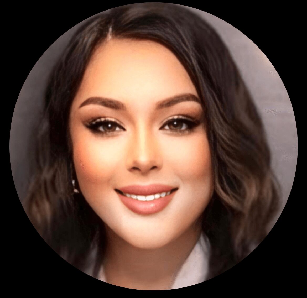 Close-up of a woman with wavy dark hair, makeup, and a smile.