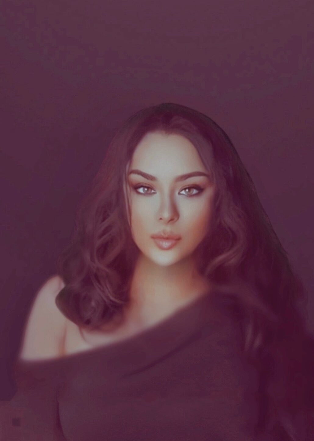 Portrait of a woman with wavy hair and makeup, looking directly at the camera against a dark background.
