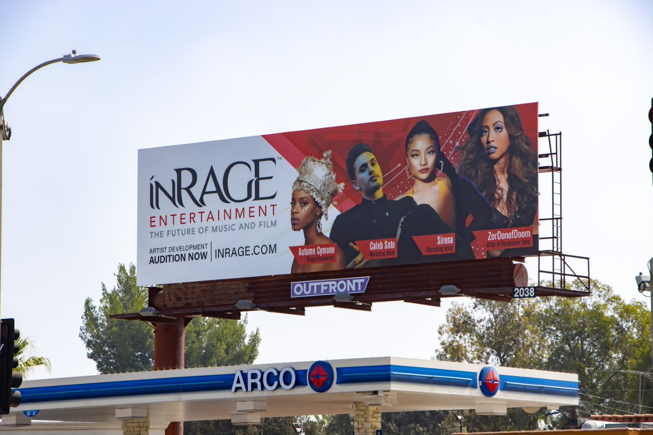 Large billboard advertising In Rage Entertainment featuring four women with different hairstyles and makeup.