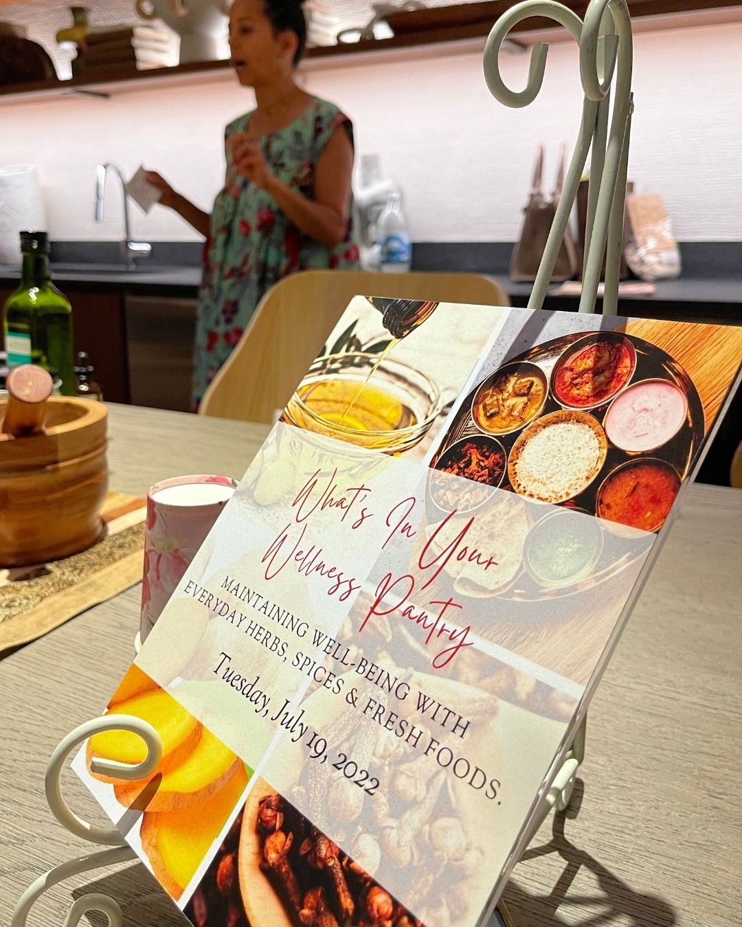 Booklet on a stand with food images and text about a wedding and party event, on a table with a person in background.