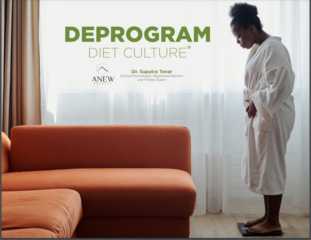 Woman in white robe looking down in a room with a sofa and window with curtains.