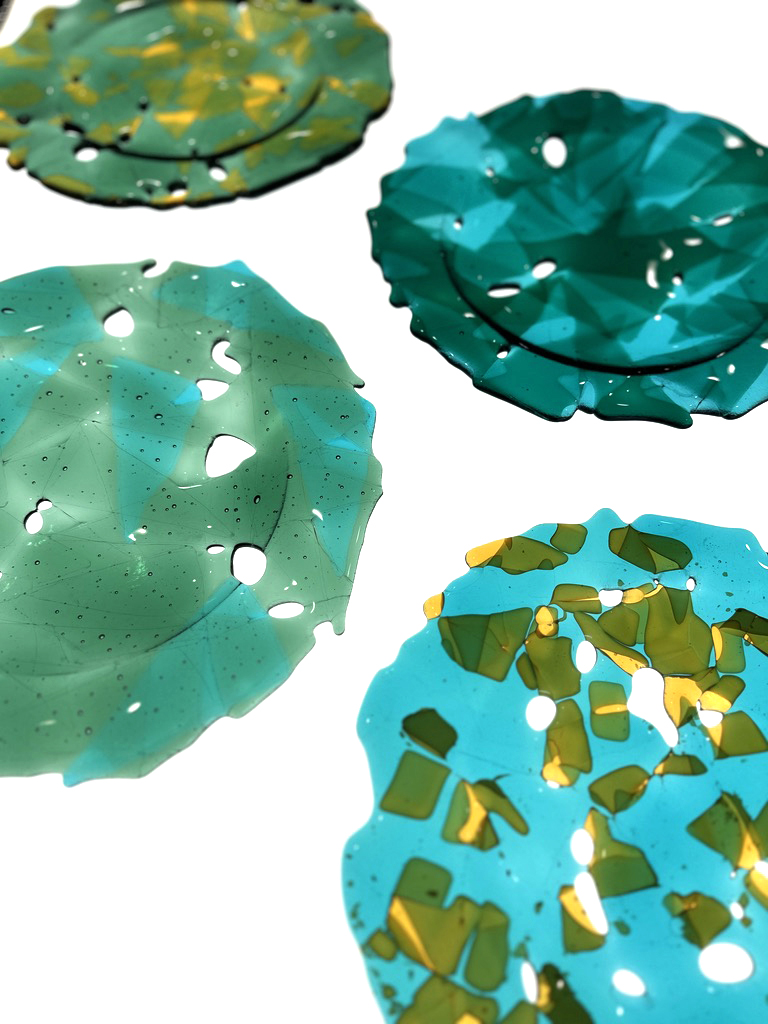 Four colorful, textured objects resembling abstract leaves or organic shapes with holes and patterns.