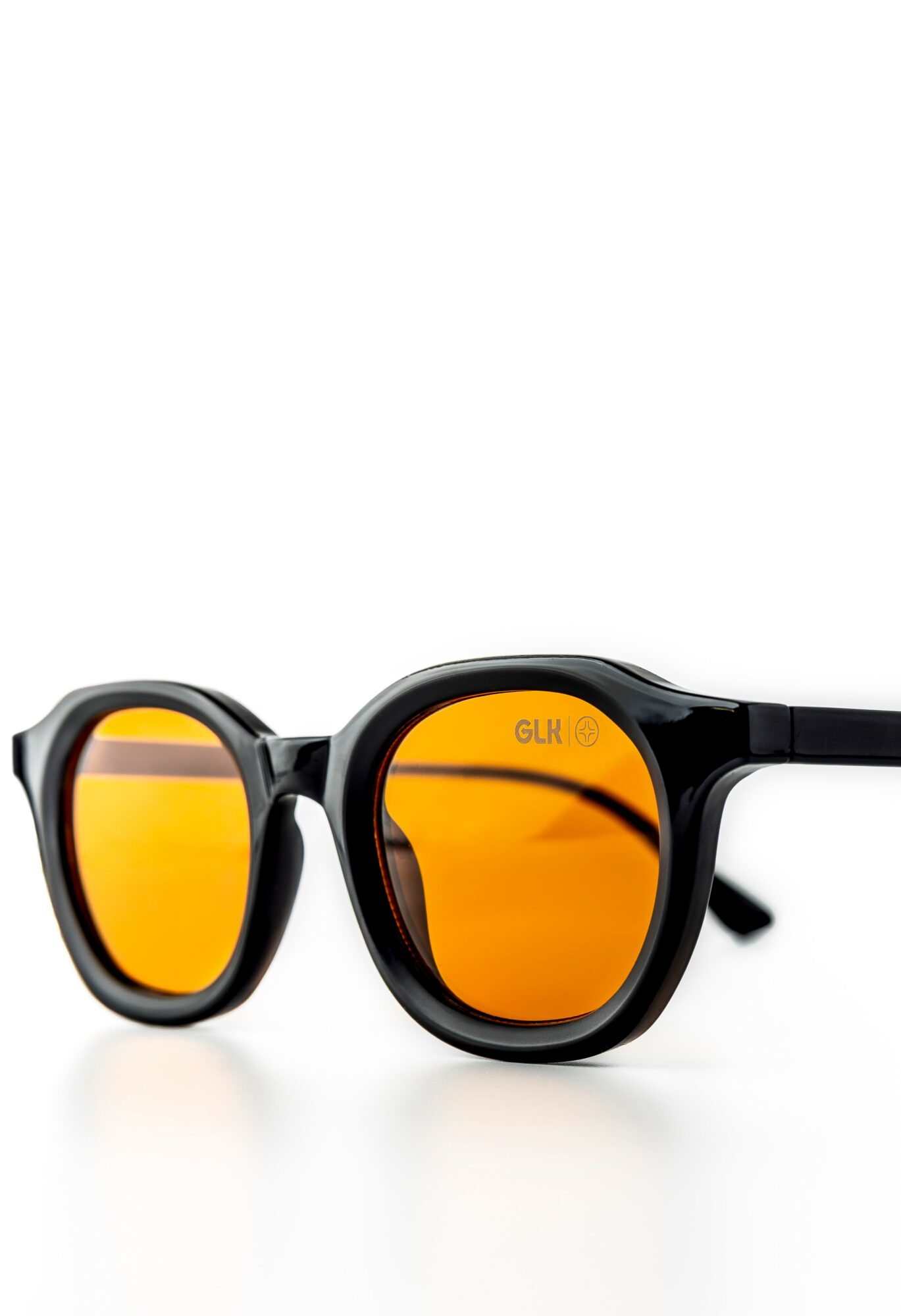 Black sunglasses with orange-tinted lenses on a white background.