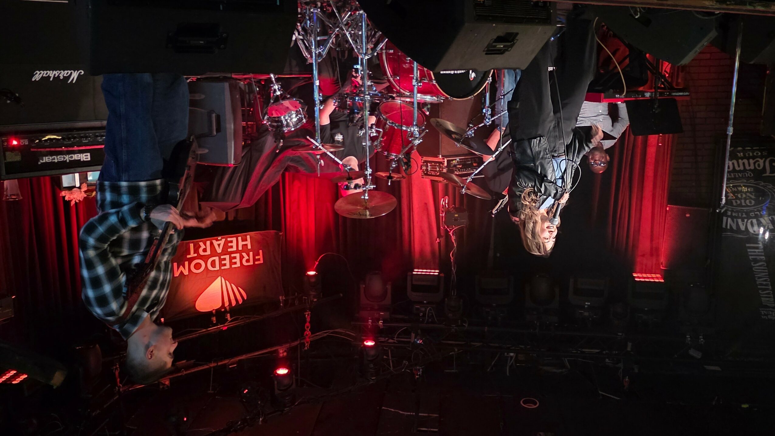 A person performing on stage with red curtains and a Christmas tree in the background.