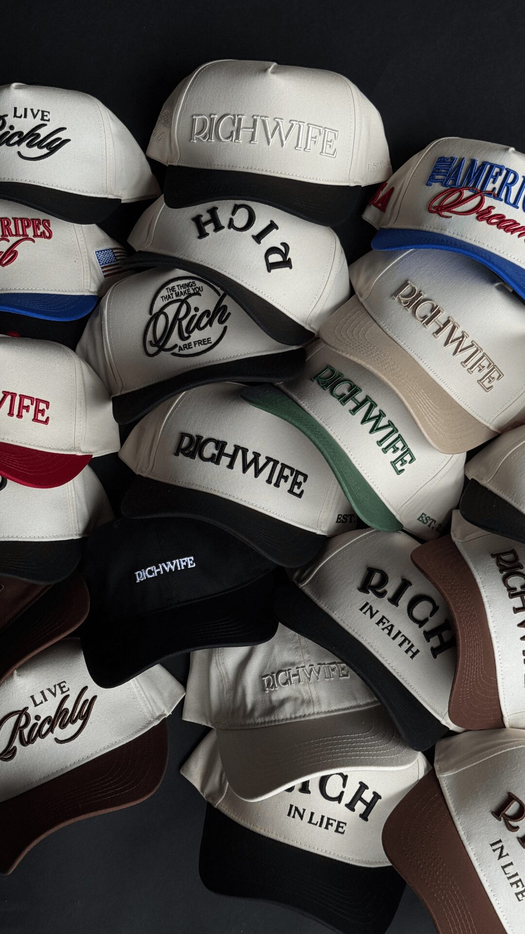 Stacked baseball caps with various logos and colors, some with text like 'Rich Wipe' and 'In Life'.