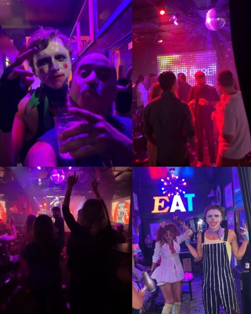 Group of people at a party with colorful lights, dancing, and a stage with a performer in striped outfit.