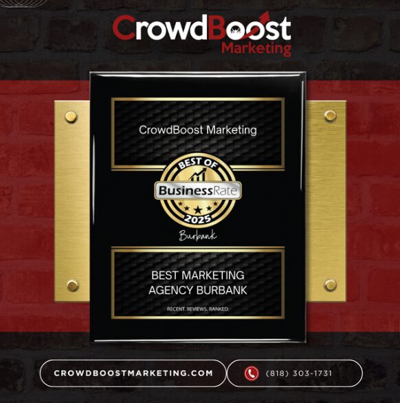Award plaque with 'CrowdBoost Marketing' and 'Best Marketing Agency Burbank' text, gold and black design, mounted on brick wall.