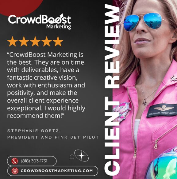 Woman wearing sunglasses and pink jacket, with a reflection in her sunglasses, standing outdoors.