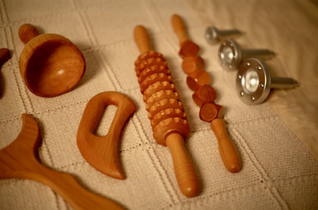 Wooden toy tools and a small wooden hammer on a fabric surface.