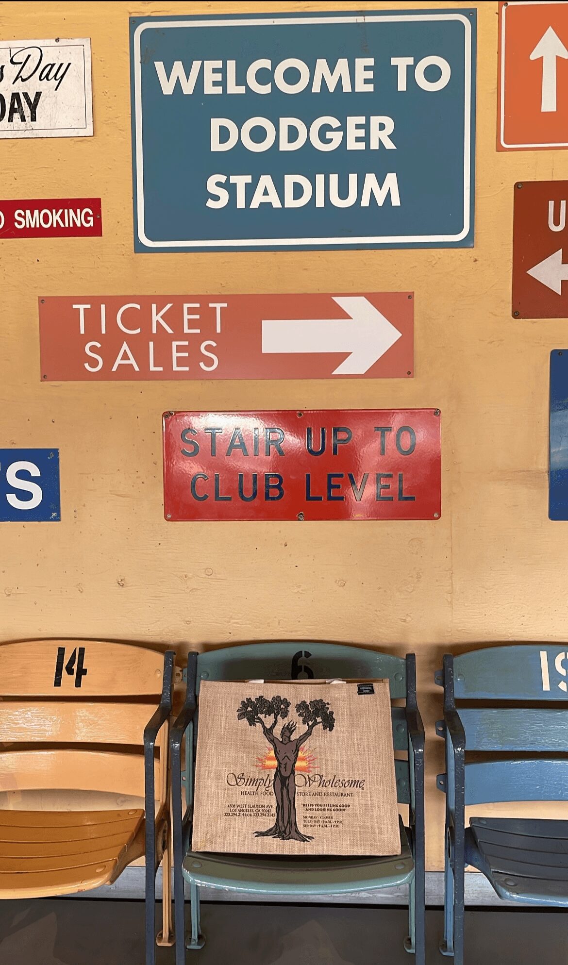 Signs and chairs at stadium entrance, ticket sales, club level stairs, and welcome sign visible.