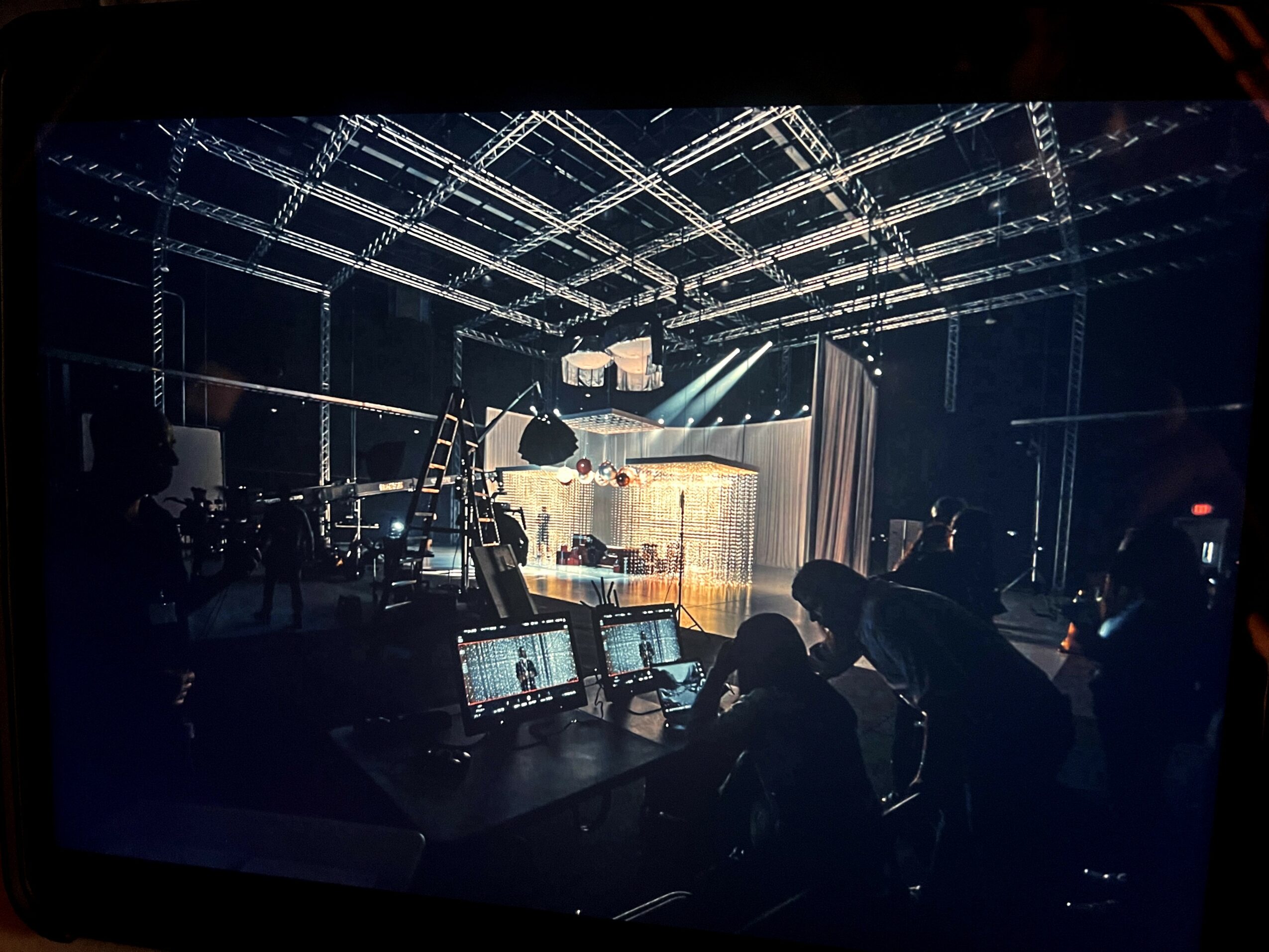 Stage with lighting and equipment, people working at control panels, dark environment, stage setup for a performance.