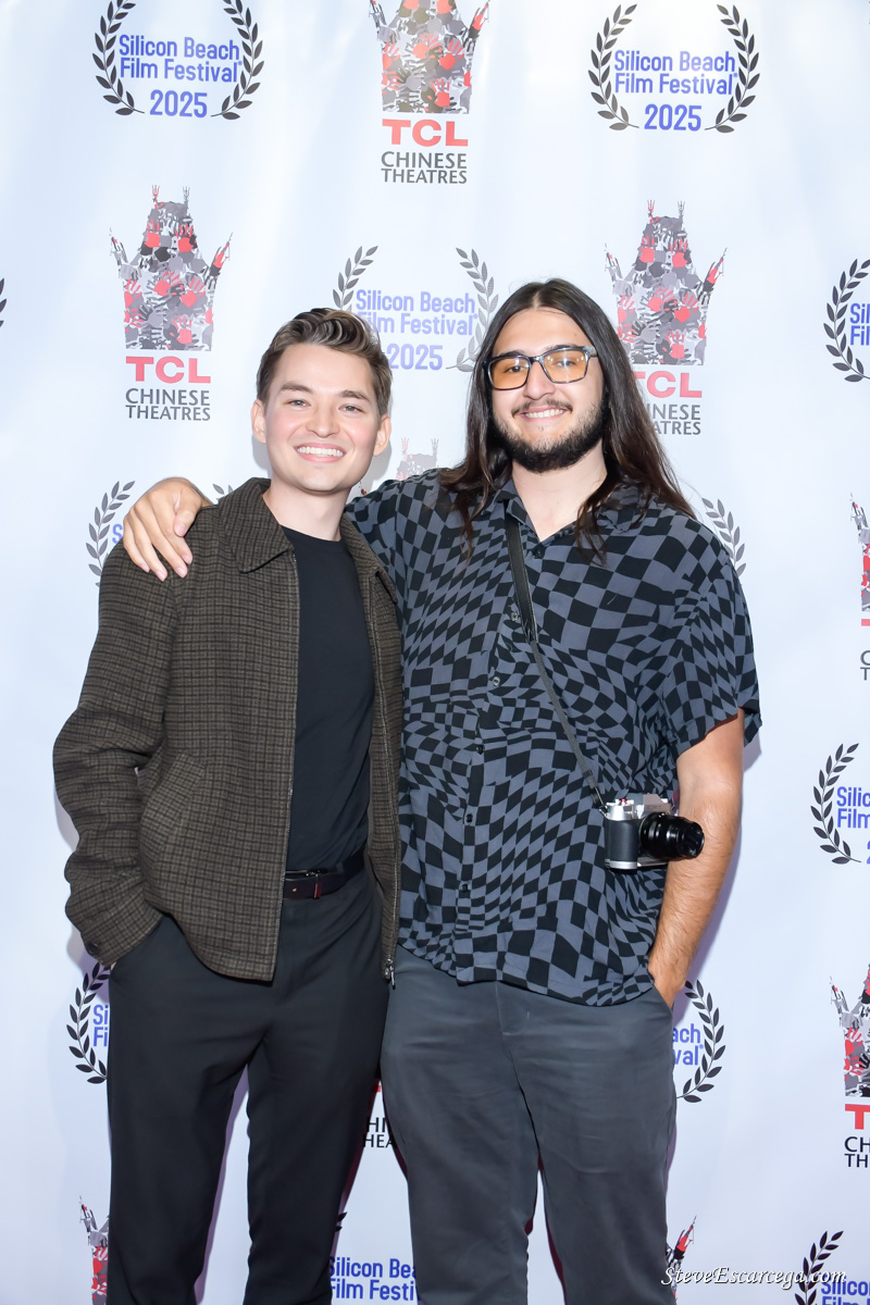 Two men standing together, smiling, with a backdrop featuring logos and text related to the Silicon Beach Film Festival 2025.