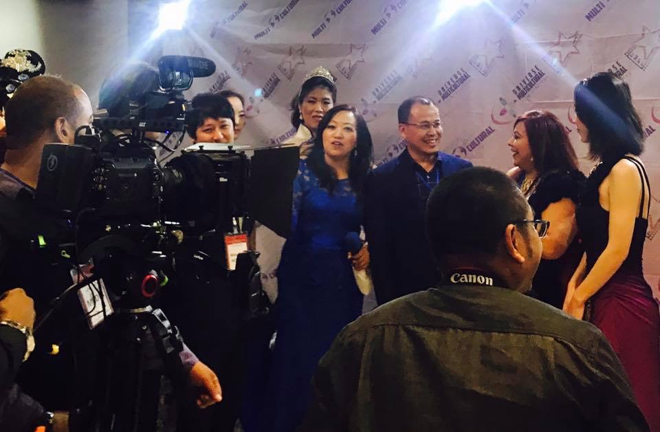 Group of people being filmed or photographed, with cameras and crew members present.