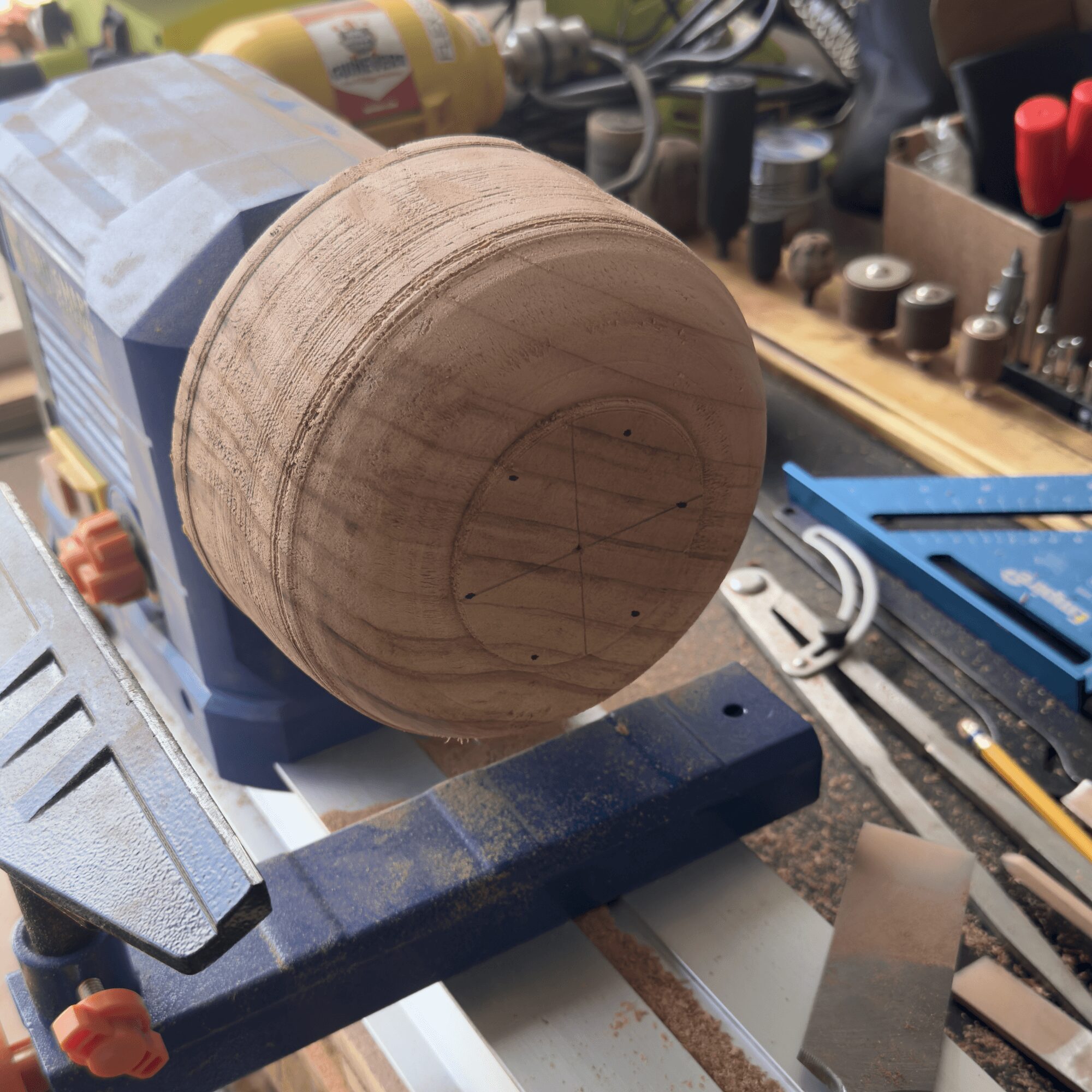 Wooden sphere on a workbench with tools and equipment around it.