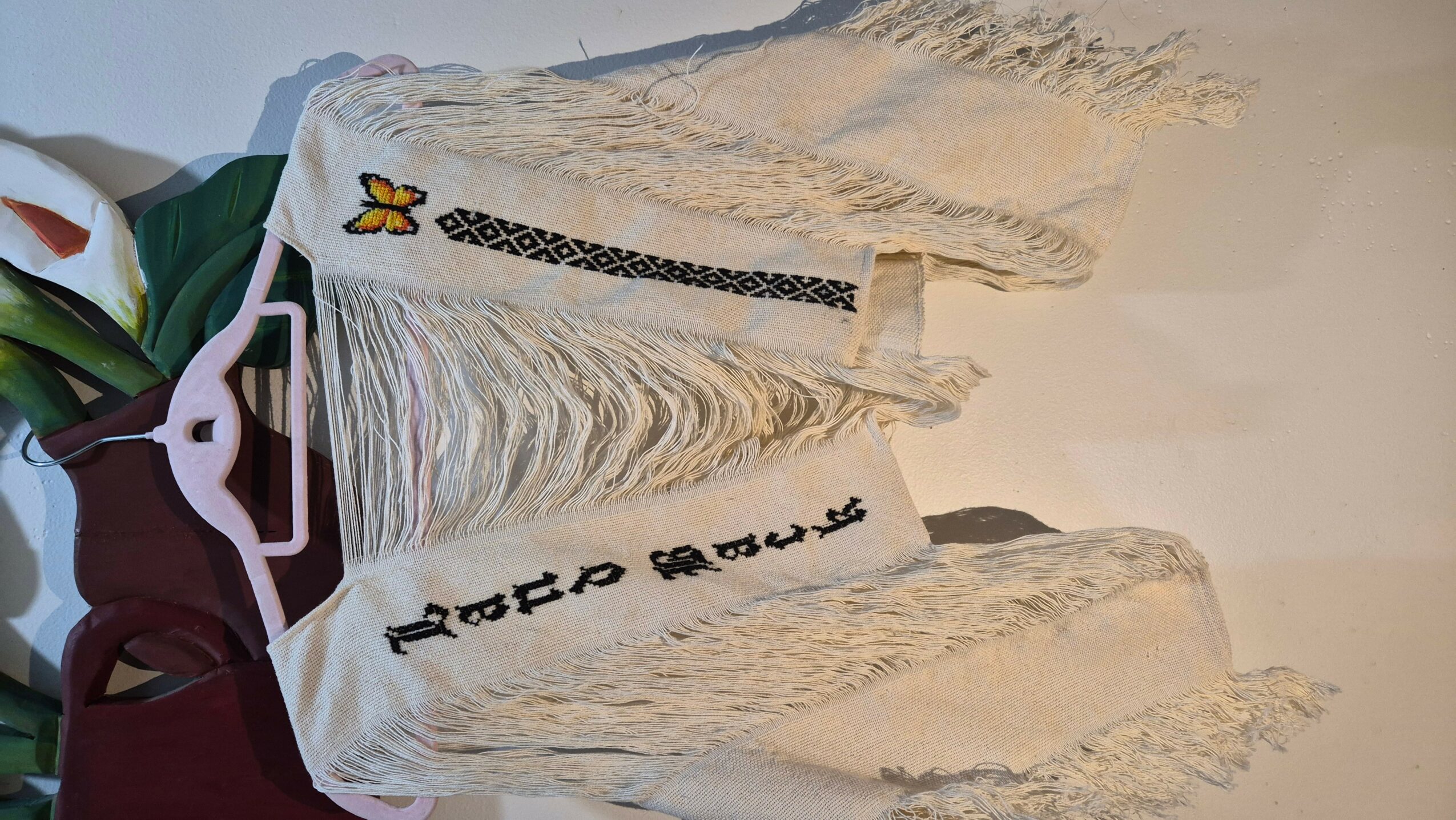 Decorative cake with white icing, black and yellow butterfly decoration, and a white ribbon with black text.