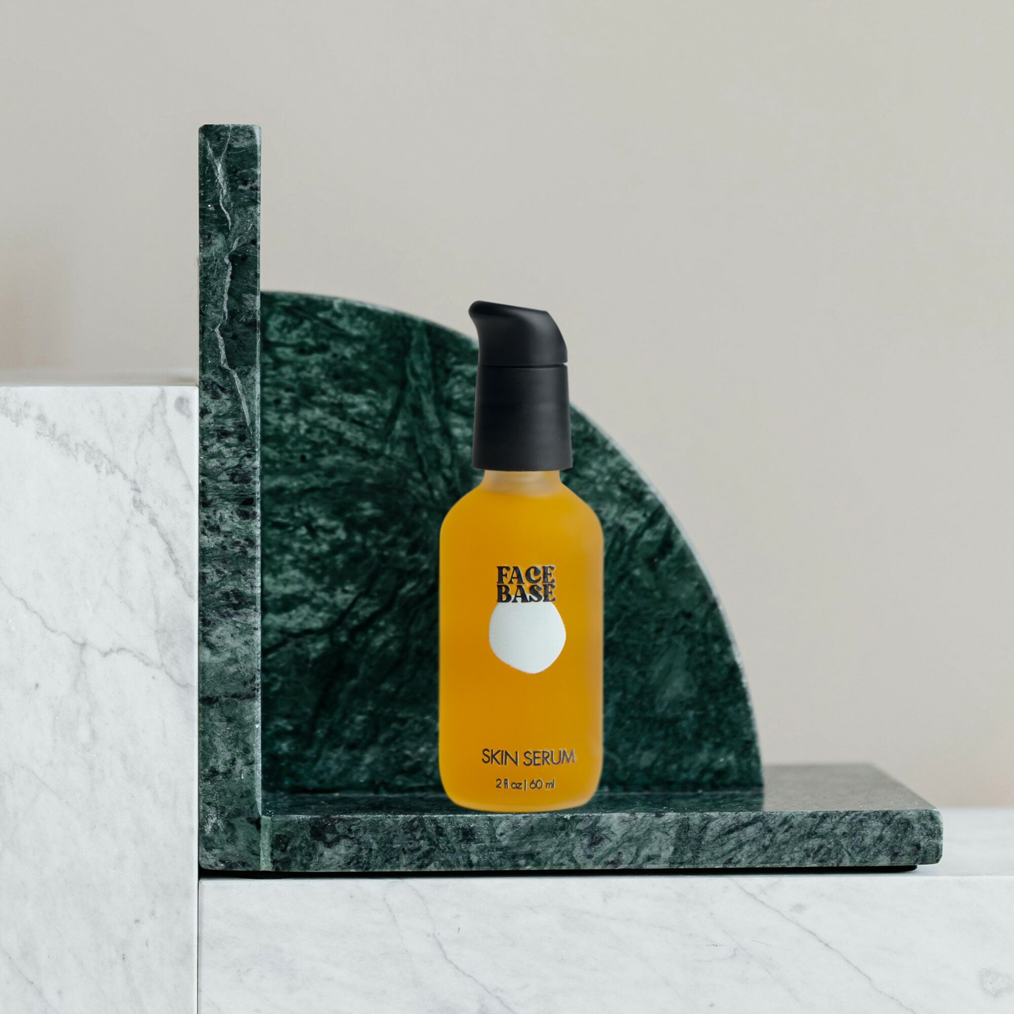 Yellow bottle labeled 'Face Basic' on green marble shelf against a light background.