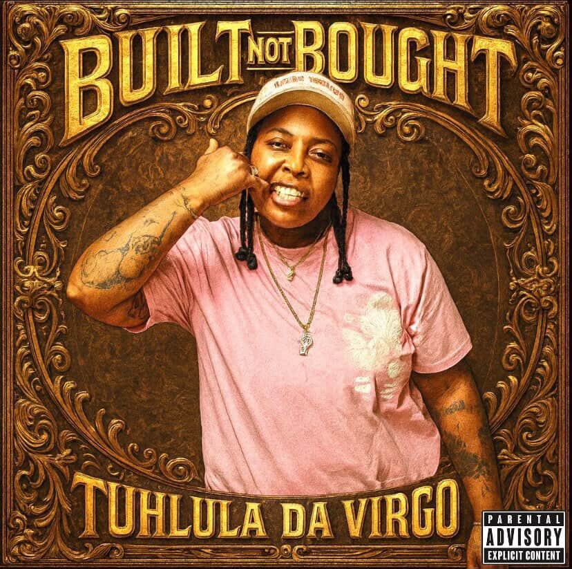 Person with braids, wearing a pink shirt and cap, making a fist near face, in front of a decorative background.