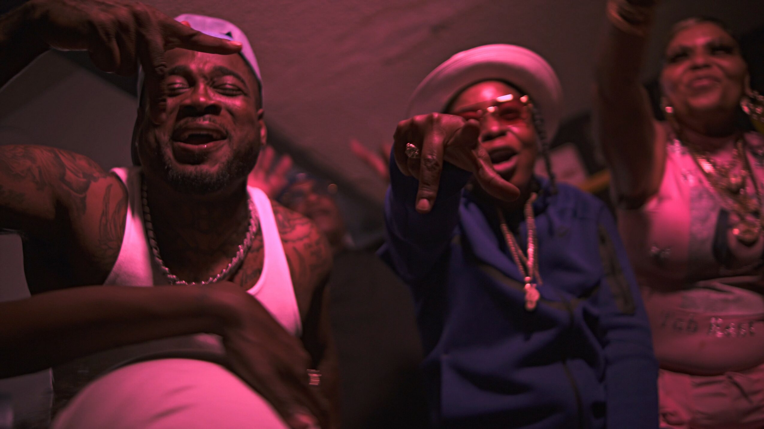 Three people smiling and raising their hands at a celebration or party.