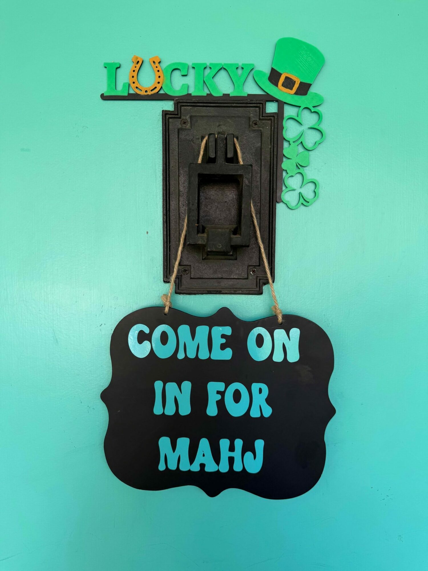Decorative St. Patrick's Day sign with a leprechaun hat and a black cloud-shaped sign reading 