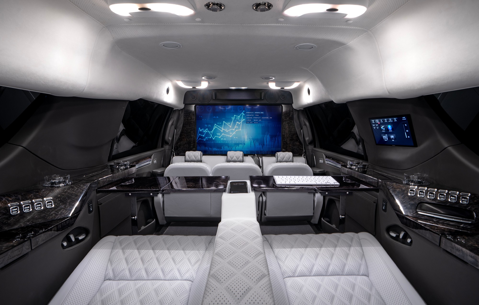 Luxury spaceship interior with seats facing a large screen and control panels on sides.