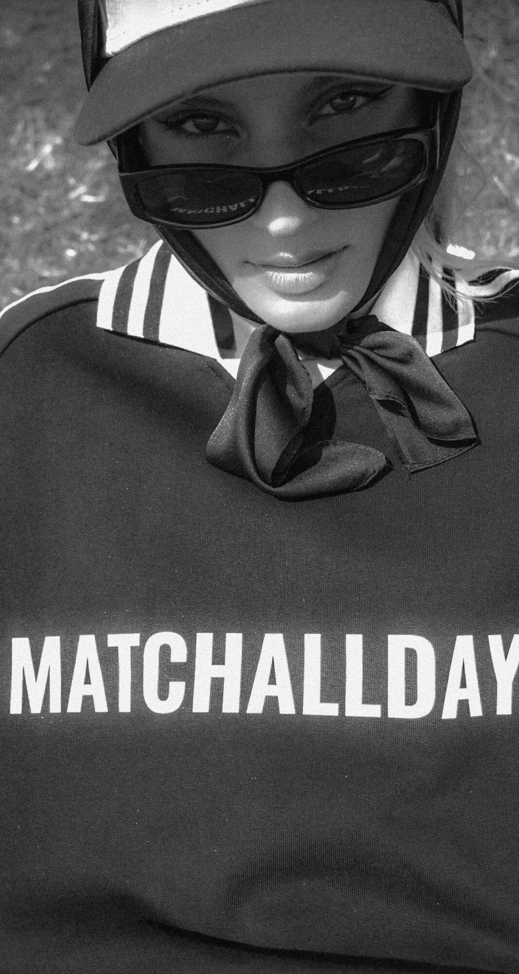 Person wearing sunglasses, cap, and a shirt with a bow tie, with text 'MATCHALLDAY' on shirt.