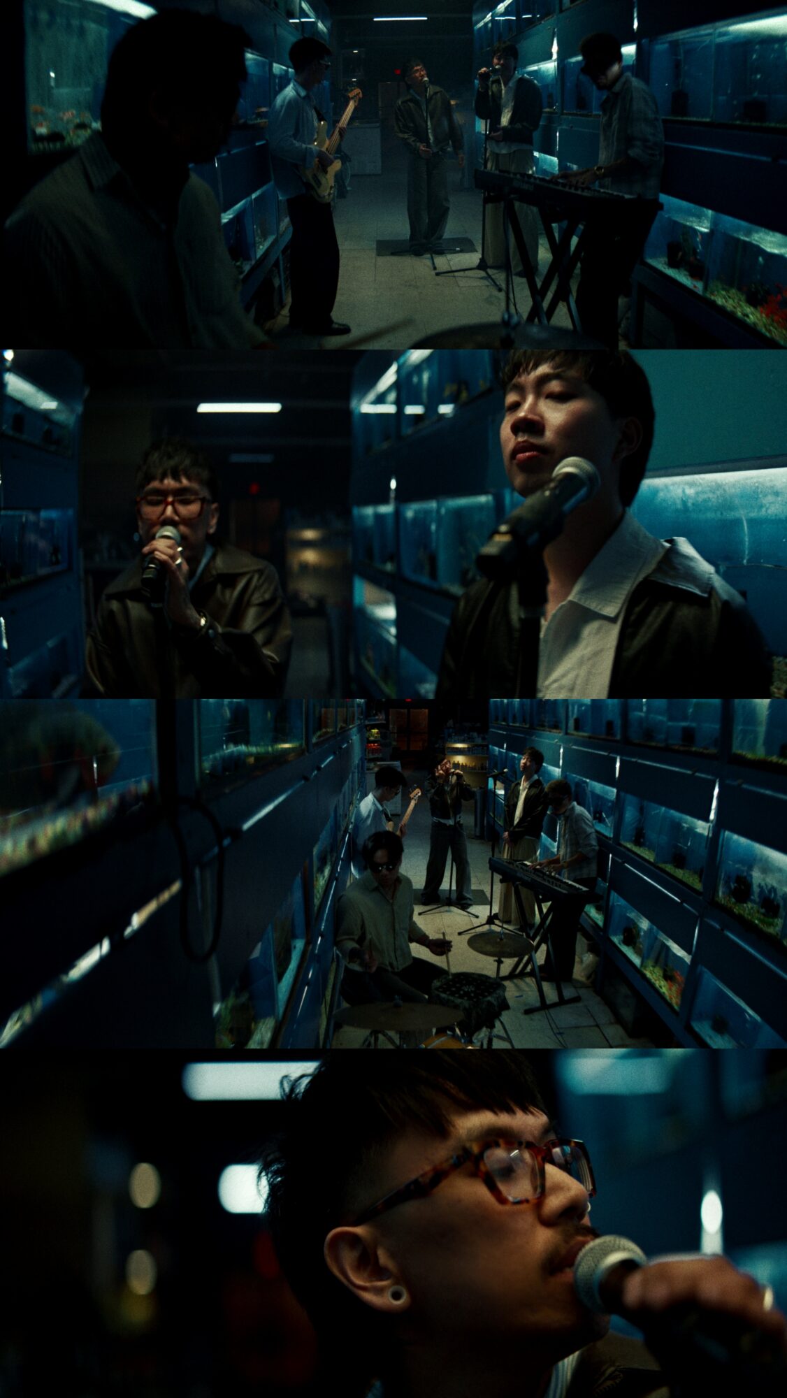 People in a dimly lit subway station, some using phones, others waiting or walking, with blue lighting and train doors.