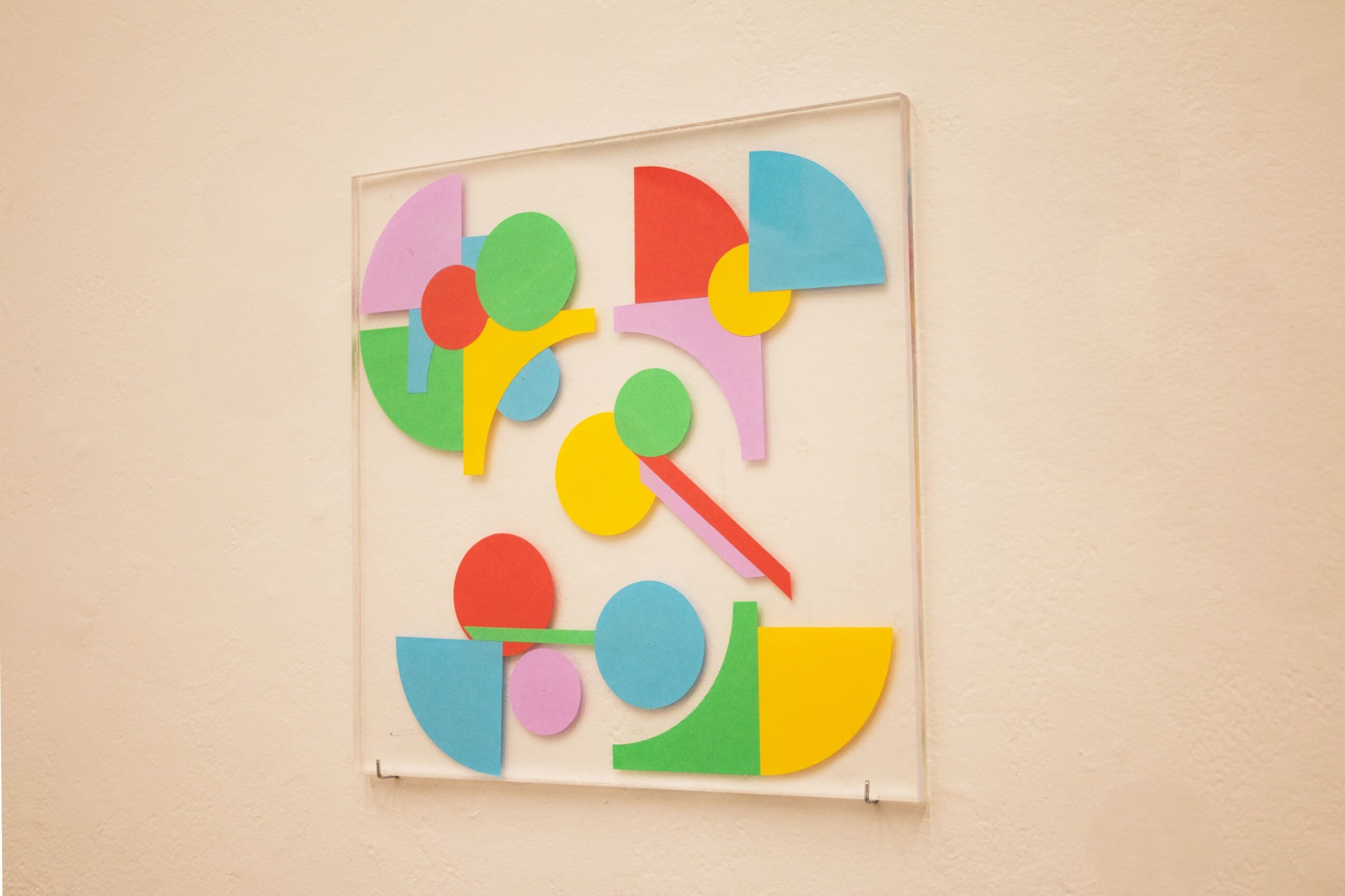 Colorful abstract shapes arranged on a white background, resembling a modern art piece or clock face.
