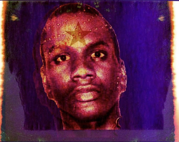 Portrait of a person with a star on forehead, dark background, colorful border, and serious expression.