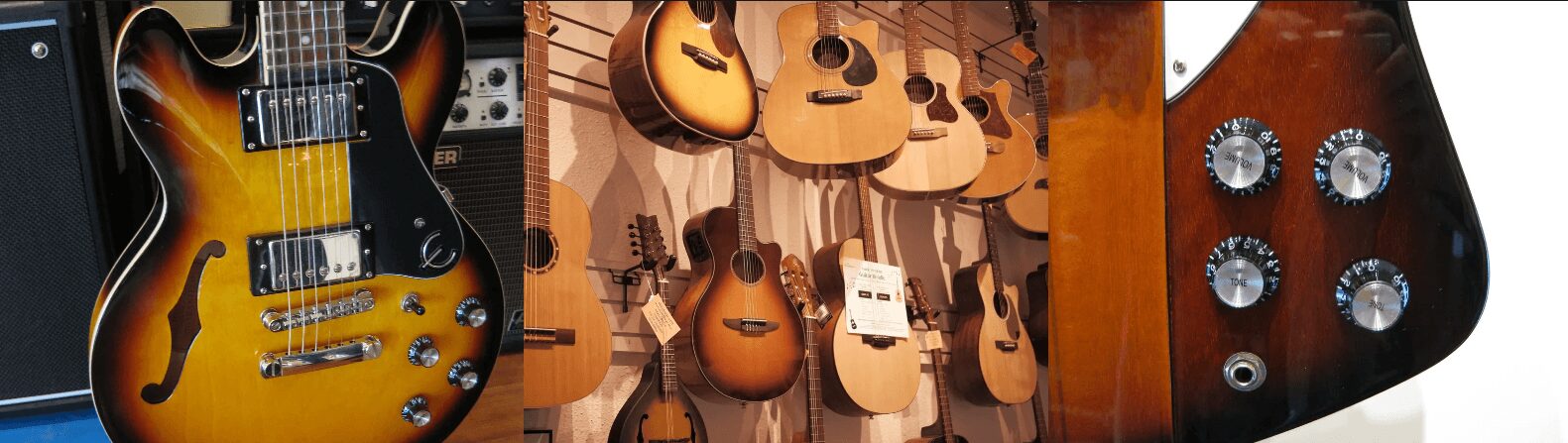 Display of various guitars on a wall, including electric and acoustic models.