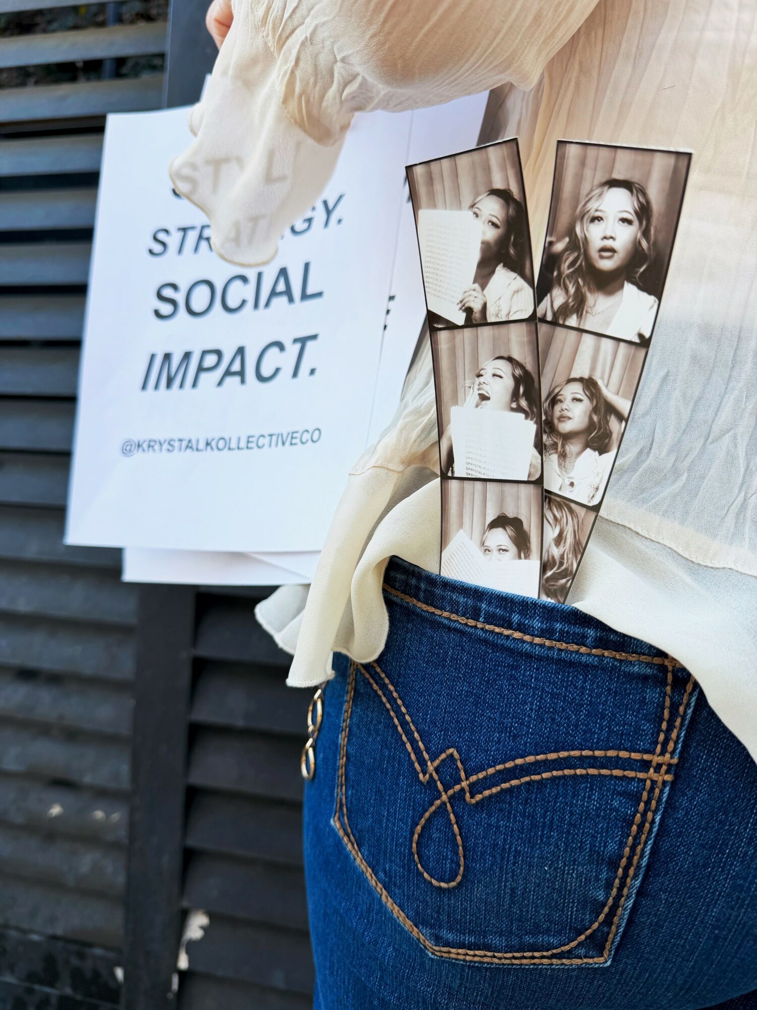 Person holding a sign with text and a photo booth strip with four pictures of a woman making different expressions.