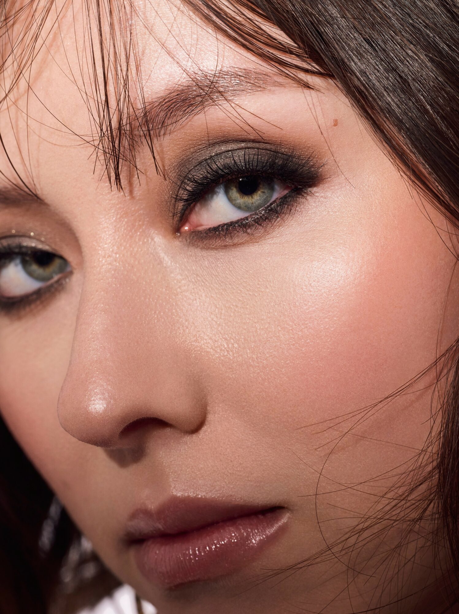 Close-up of a woman's face showing eye makeup, eyebrows, and lips.