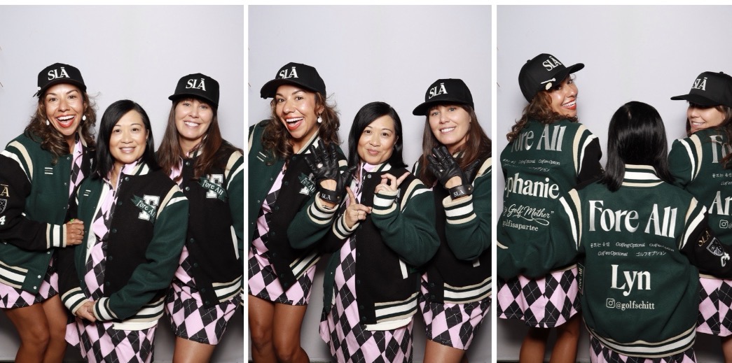 Group of five young women in matching green and black varsity jackets and plaid skirts, smiling and posing together.