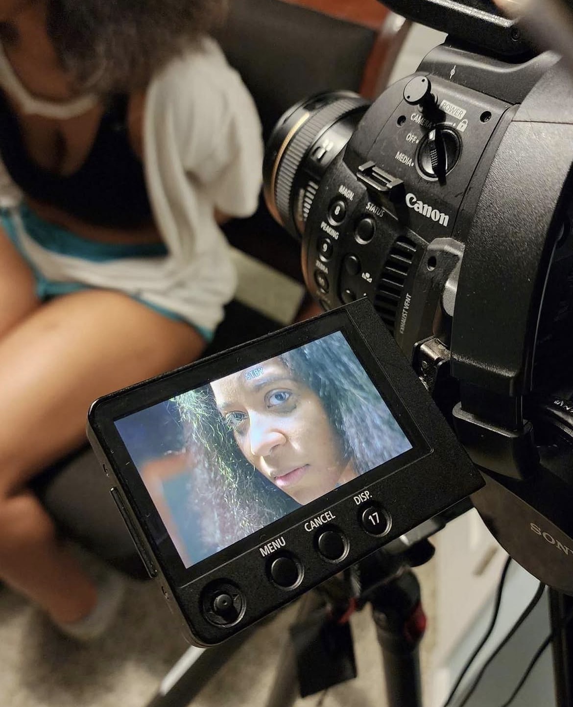 Camera viewfinder displaying a woman's face with wet hair, close-up shot.