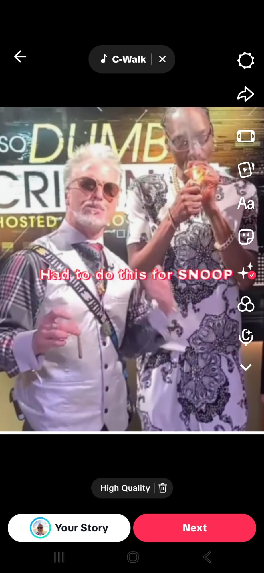 Two men standing together, one holding a drink, in front of a sign with text and images.