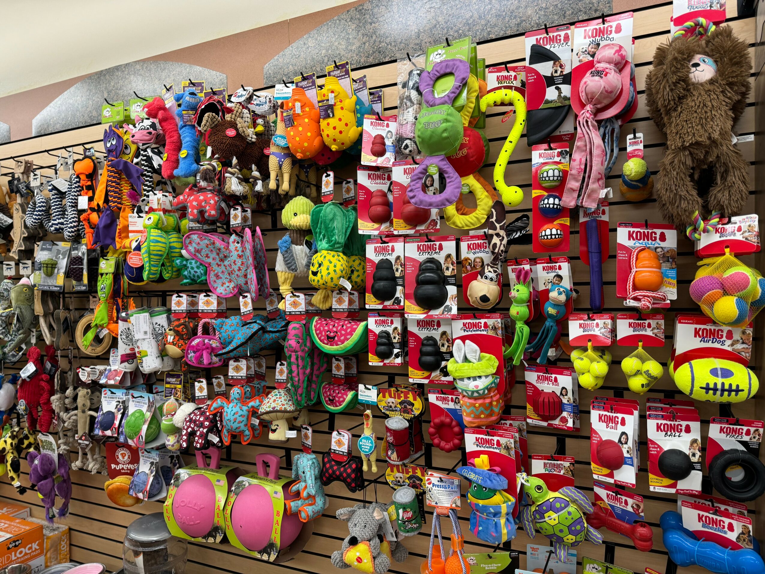 Display of colorful plush toys, balls, and toys on shelves in a store.