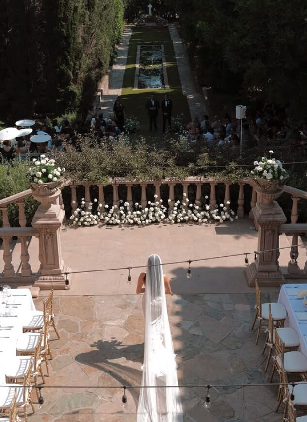 Wedding setup with chairs, floral arrangements, and a pathway leading to an outdoor gathering.