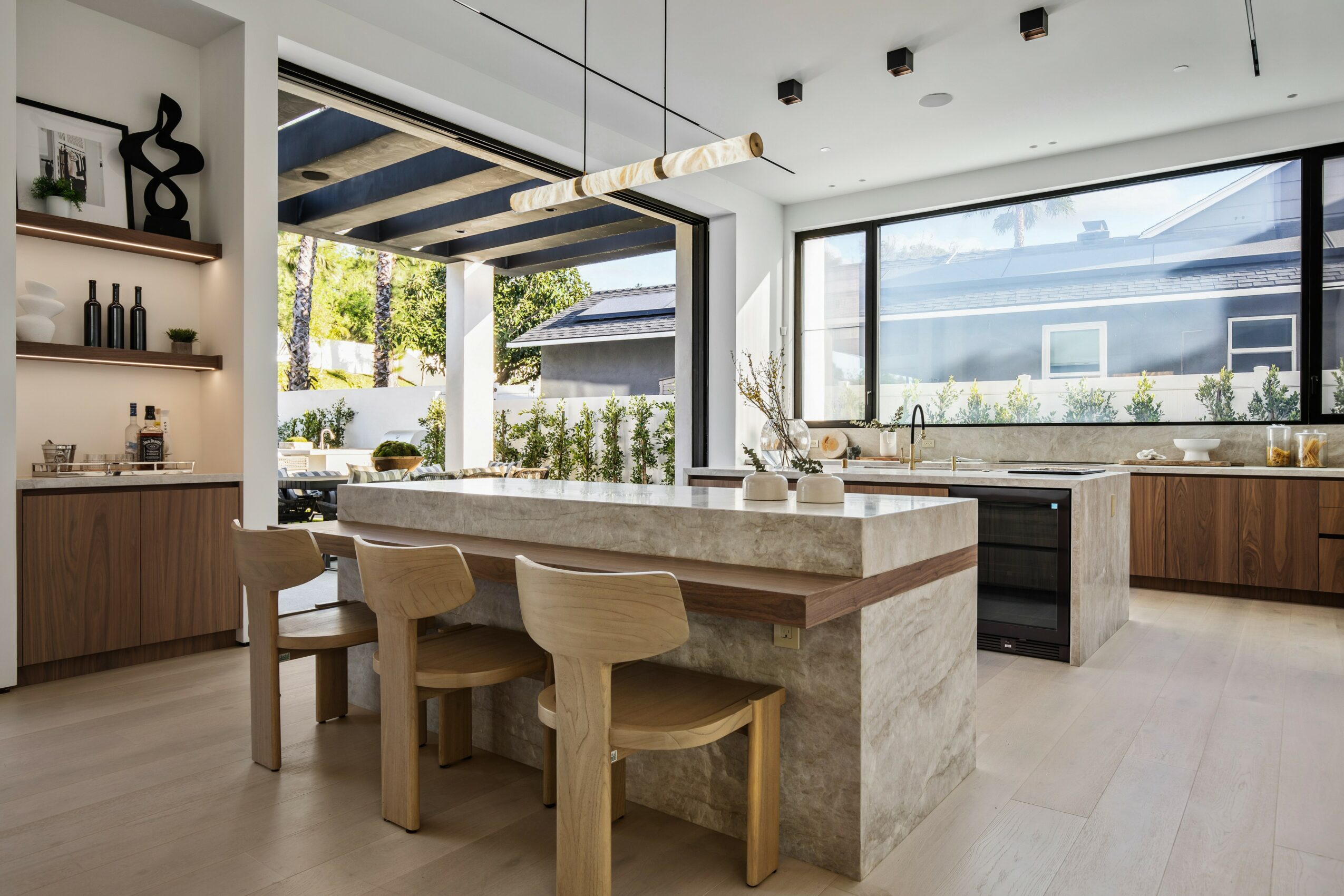 Modern kitchen with large window, island, and open shelving, bright and airy with natural light.