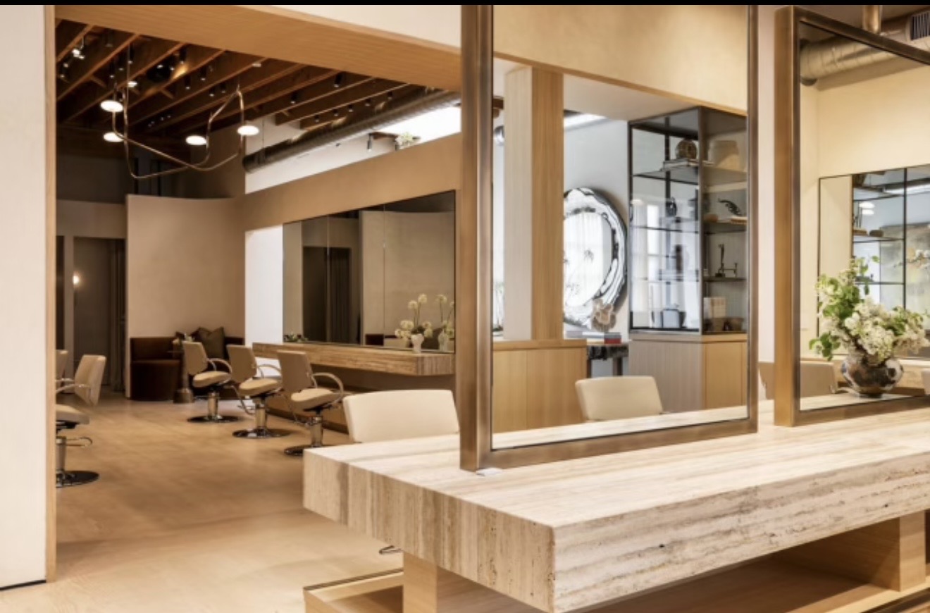 Modern interior with seating area, large windows, and wooden accents, featuring a table and decorative plants.