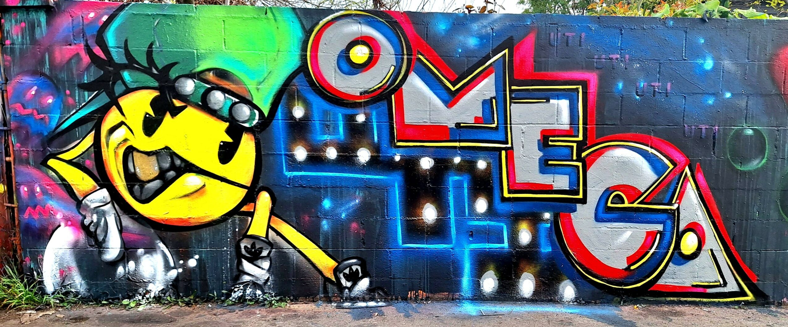 Colorful graffiti mural with a yellow cartoon character and the word 'LOVE' in bold letters on a brick wall.