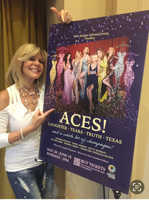 Woman smiling and pointing at a poster for a theatrical production featuring women in colorful dresses, with event details below.