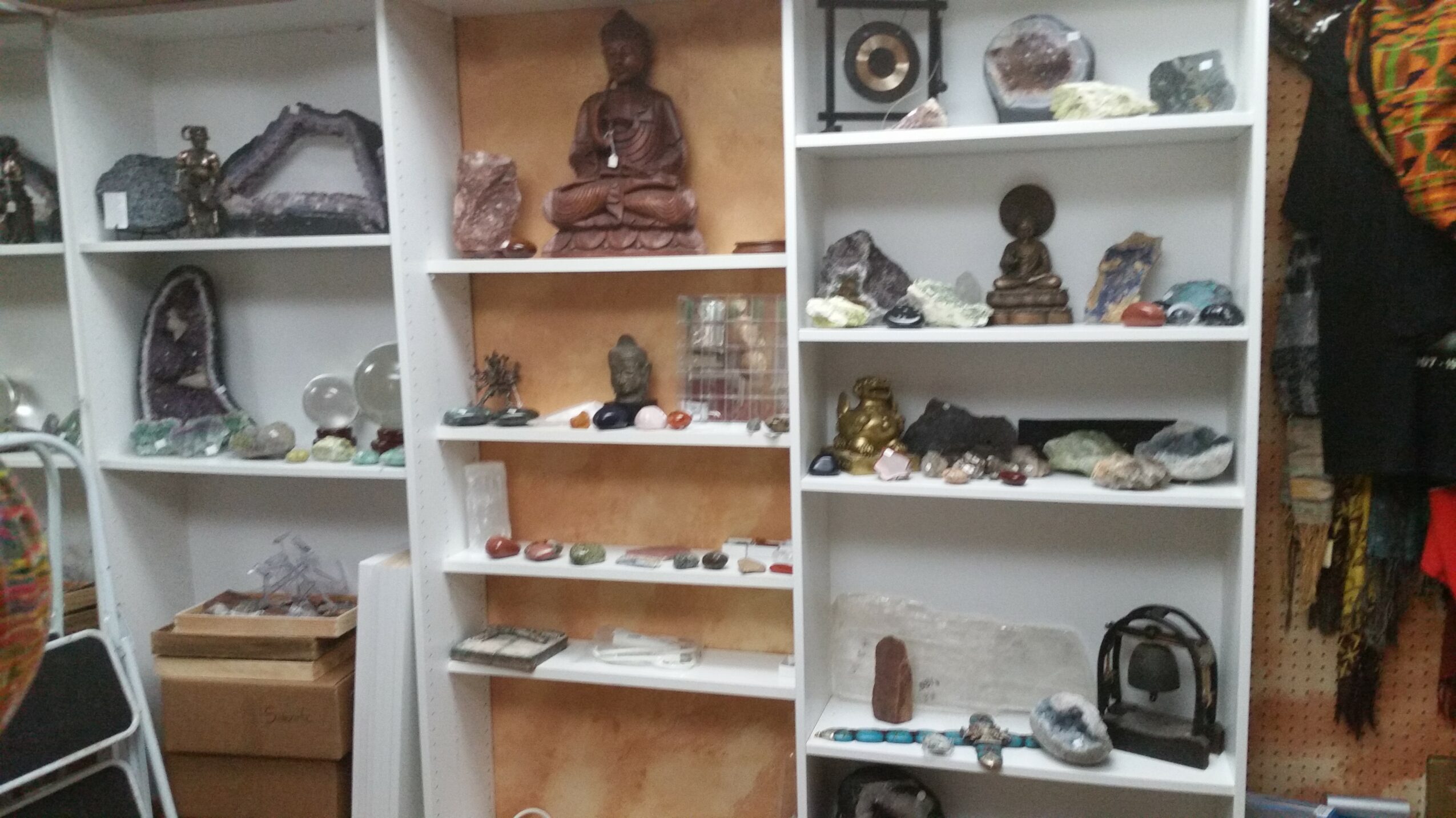 Shelves filled with various decorative objects, statues, and collectibles, with a person partially visible on the right side.