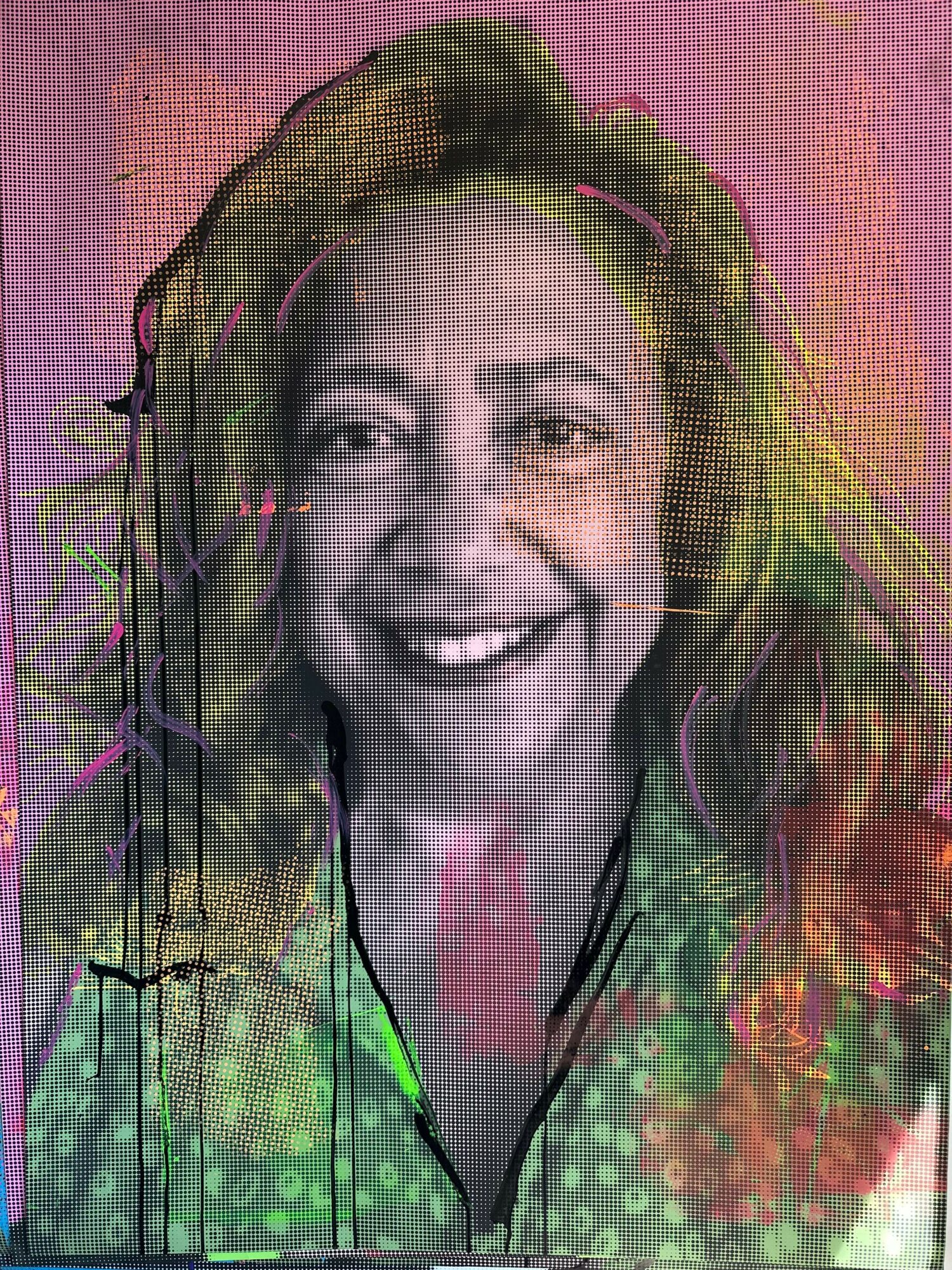 Smiling woman with long hair, wearing a patterned top, facing forward, in a close-up portrait.