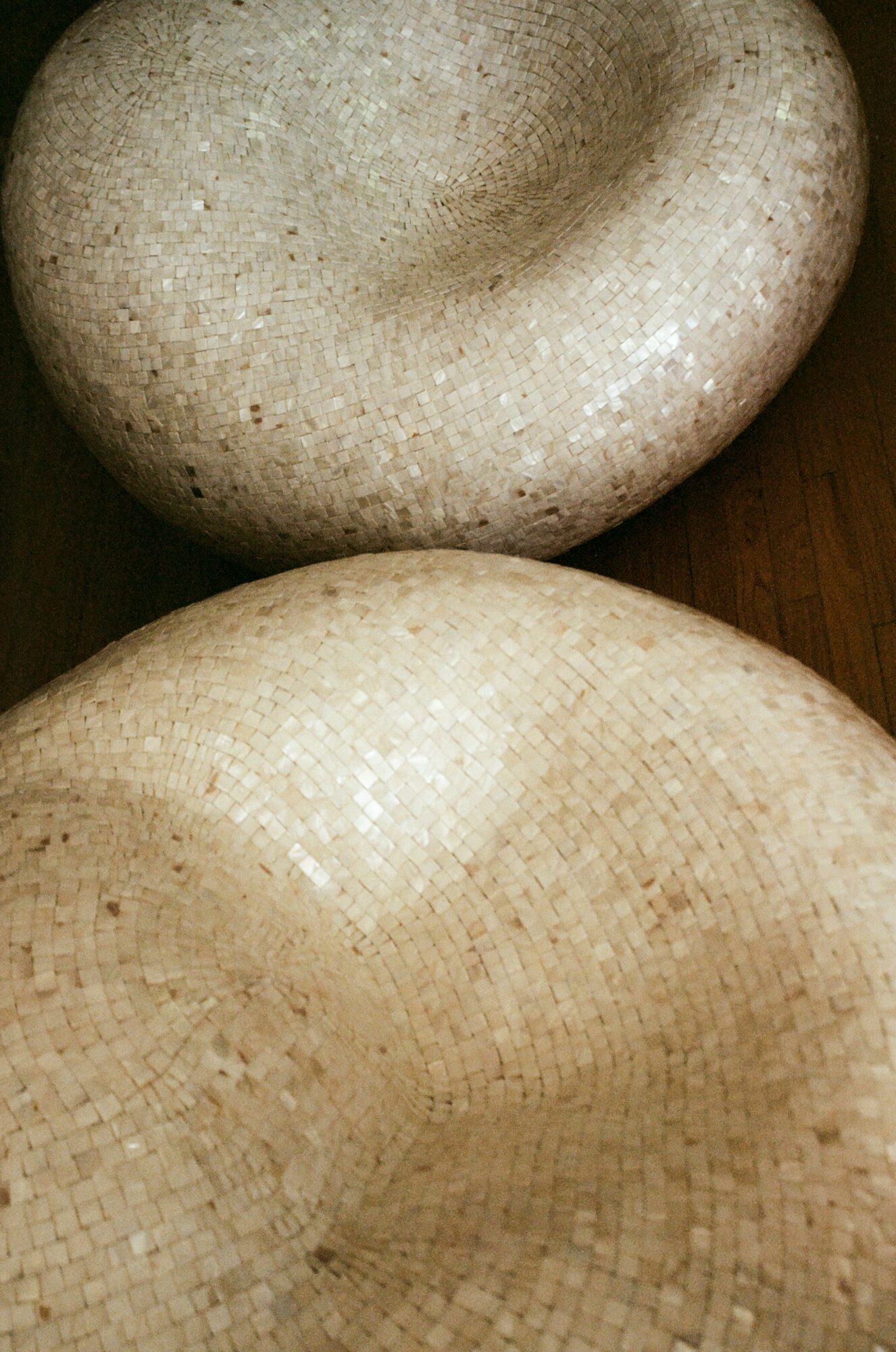 Two rounded stone objects with textured surfaces, placed on a dark surface.
