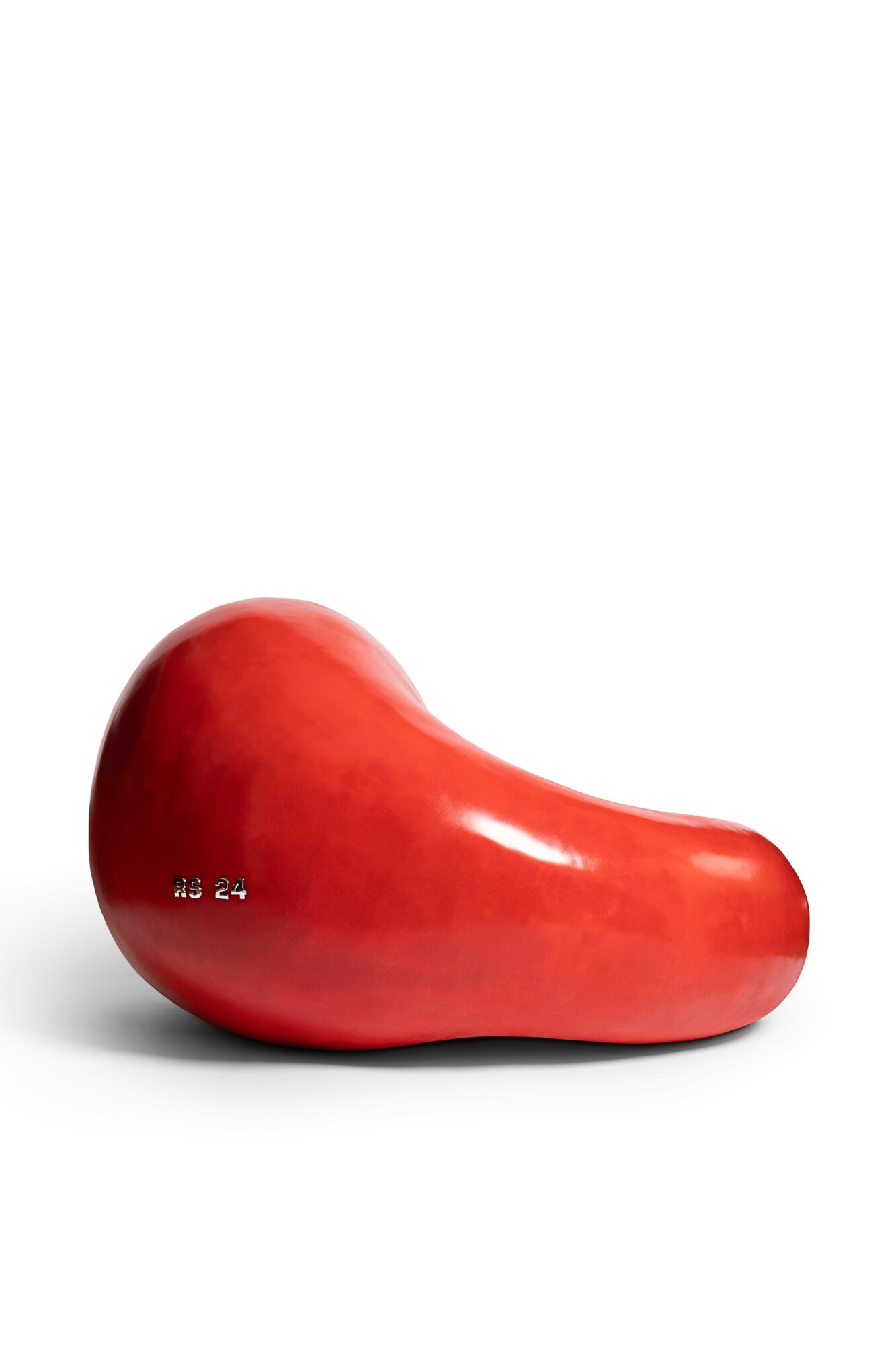 Red bean-shaped object on a white background, smooth surface, with a small label, 20 words.